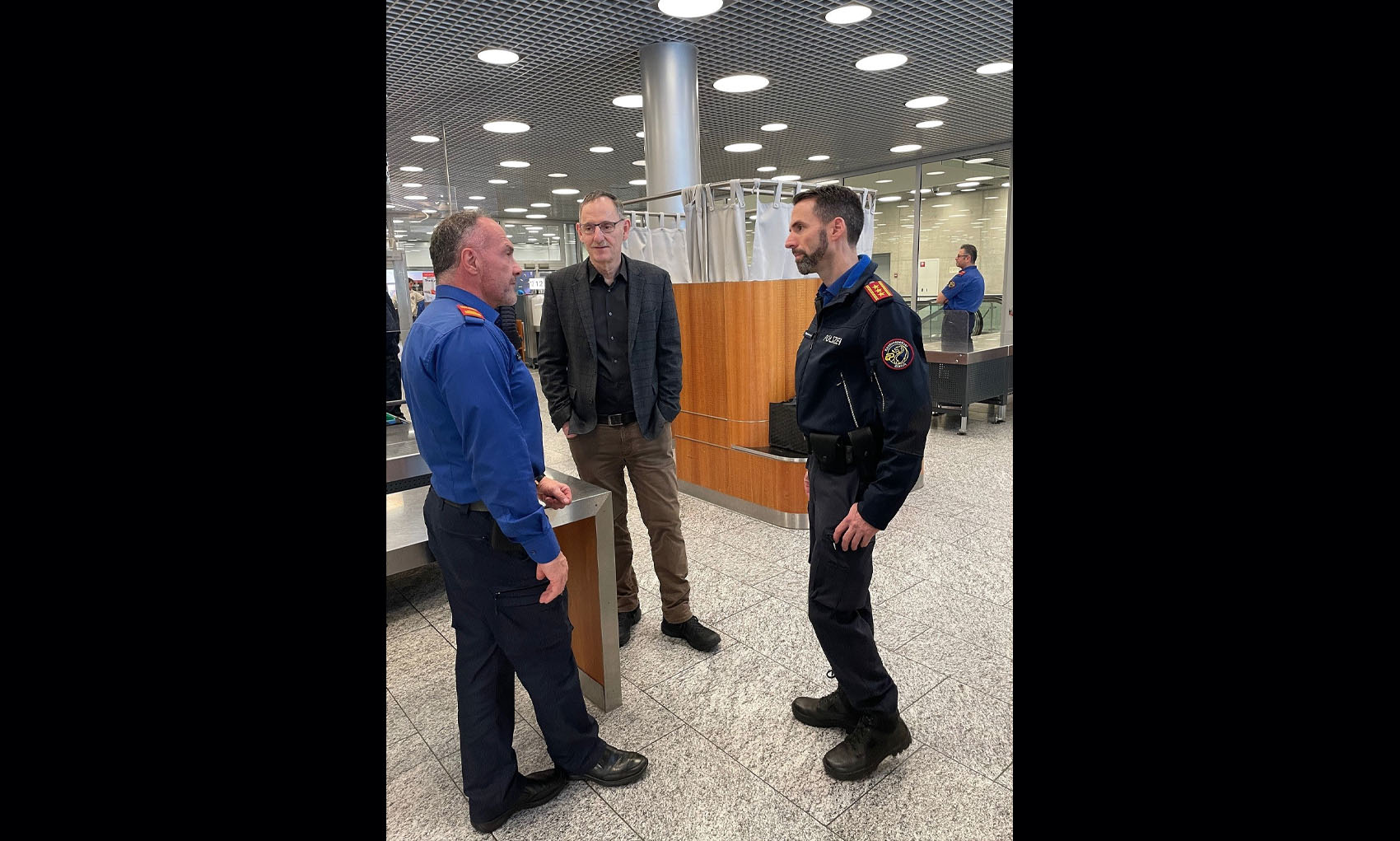 Mario Fehr und Marius Weyermann im Gespräch mit einem Kapo-Mitarbeiter am Flughafen. 