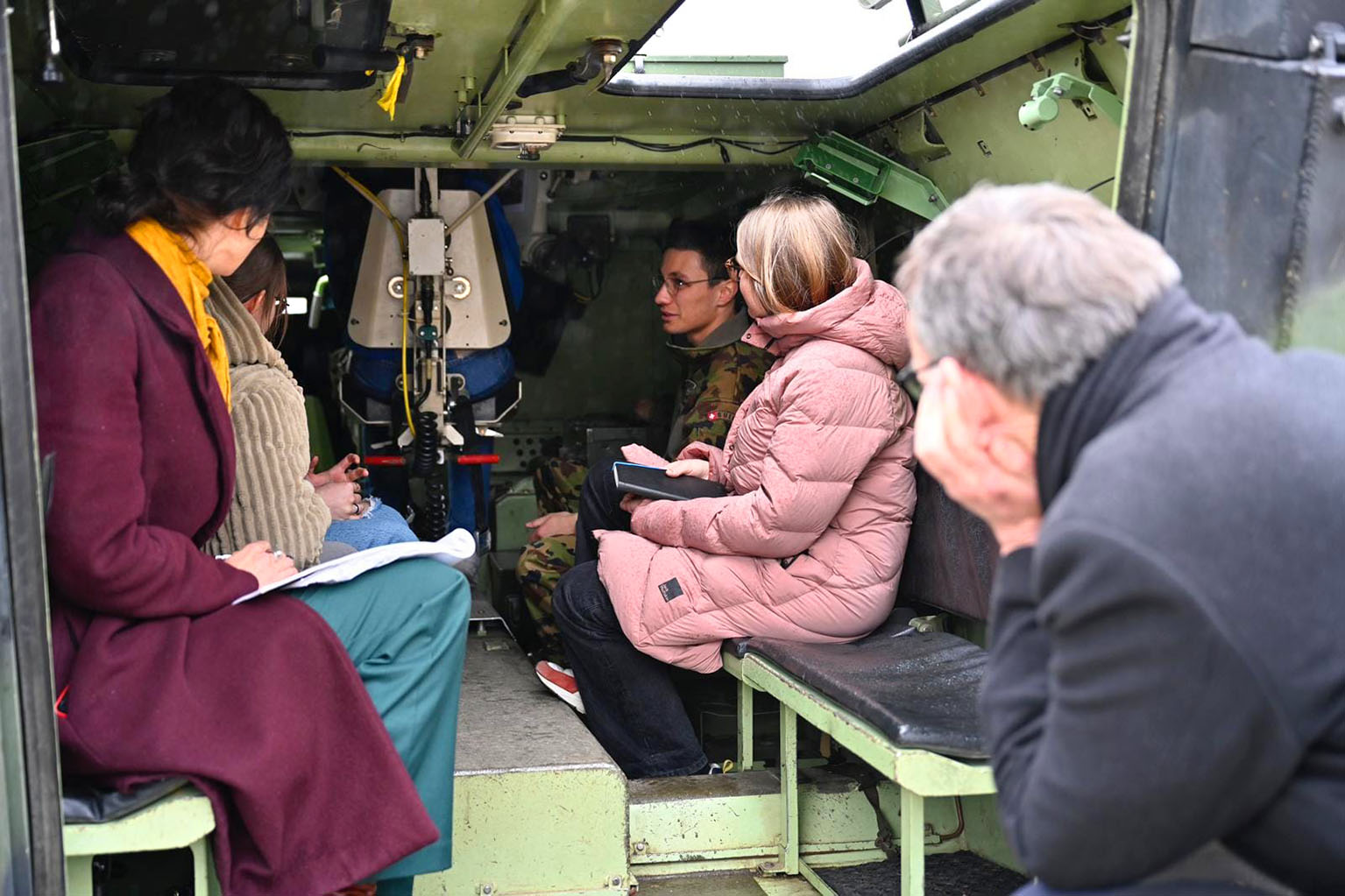 Mario Fehr wirft einen Blick in ein Fahrzeug der Armee, in welchem mehrere Personen sitzen. 