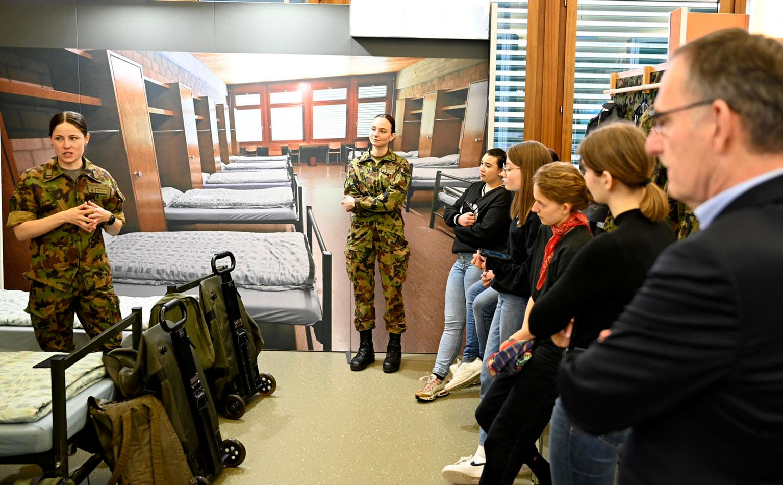 Eine Moderatorin der Armee zeigt den Besuchenden ein Soldatenzimmer. 