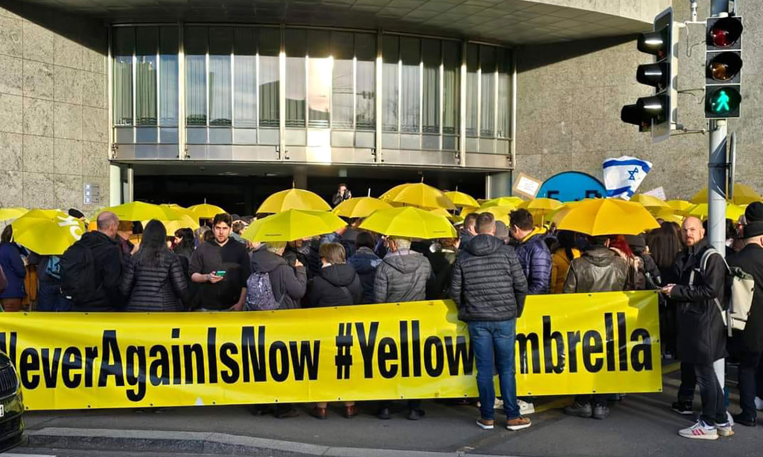 Mahnwache in Zürich: Menschenmenge mit gelben Regenschirmen. 