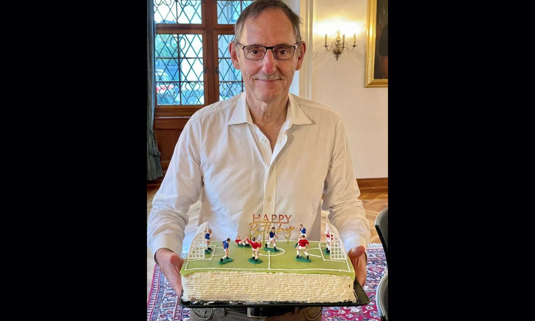 Mario Fehr mit der vom Regierungsrat überreichten Torte in Fussballfeld-Form.