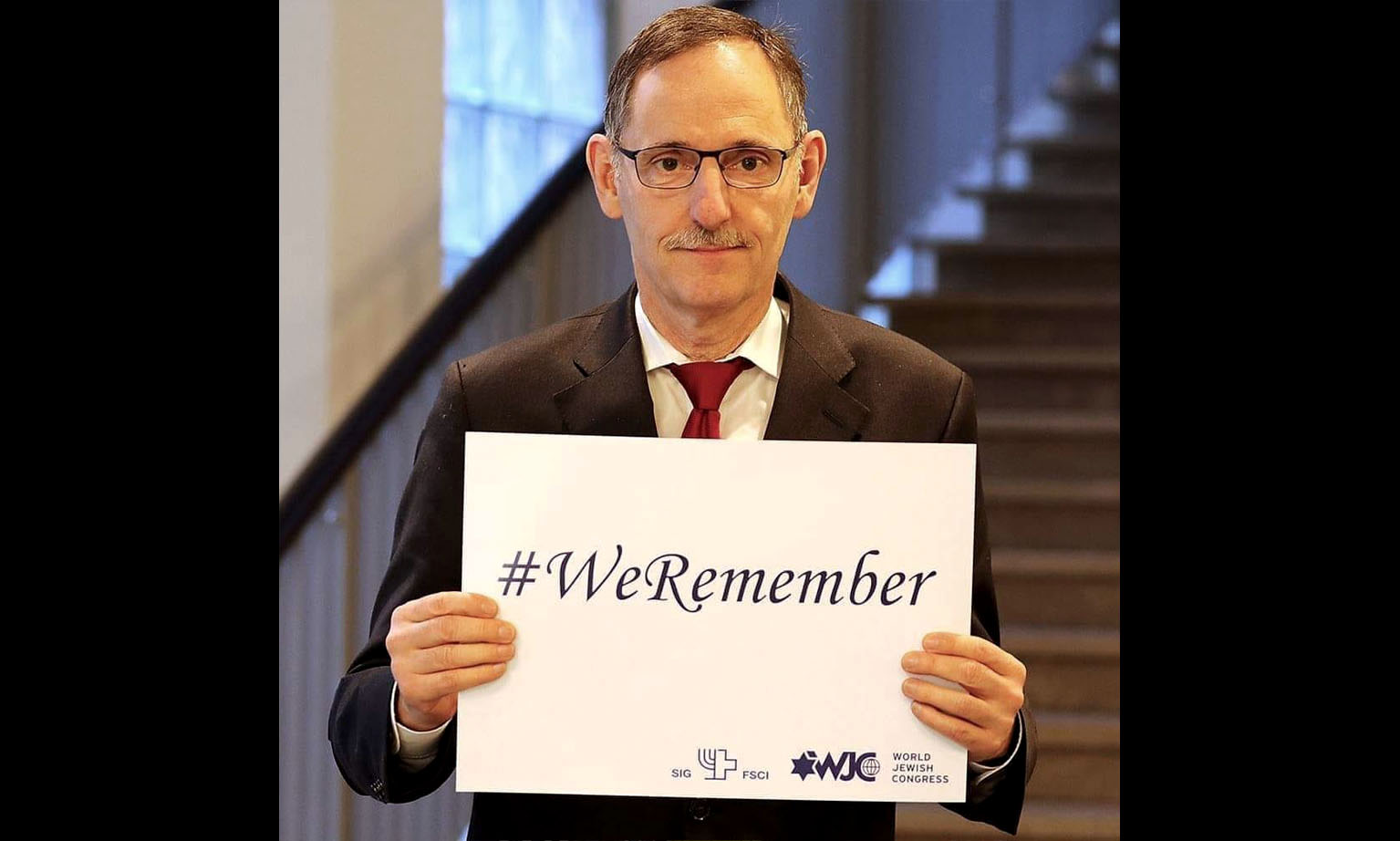 Mario Fehr hält ein Schild hoch mit dem Text «#We remember». Mit diesem Hashtag wird auch in den sozialen Medien jährlich an den Holocaust erinnert. 