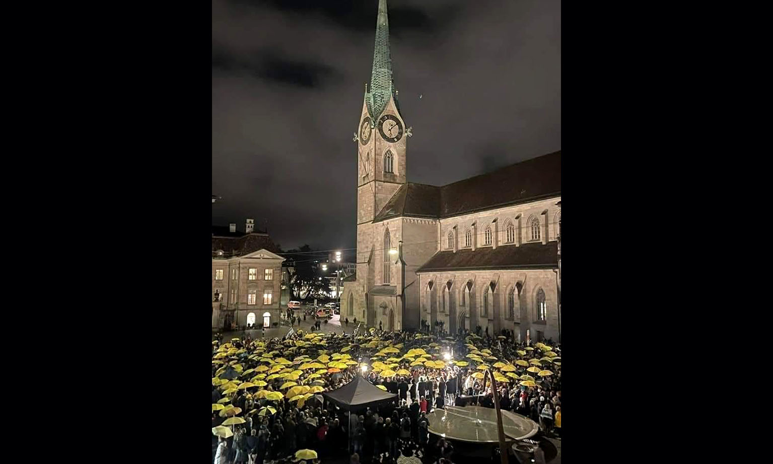 Rund 2000 Menschen auf dem Münsterhof, die meisten mit aufgespannten gelben Regenschirmen.