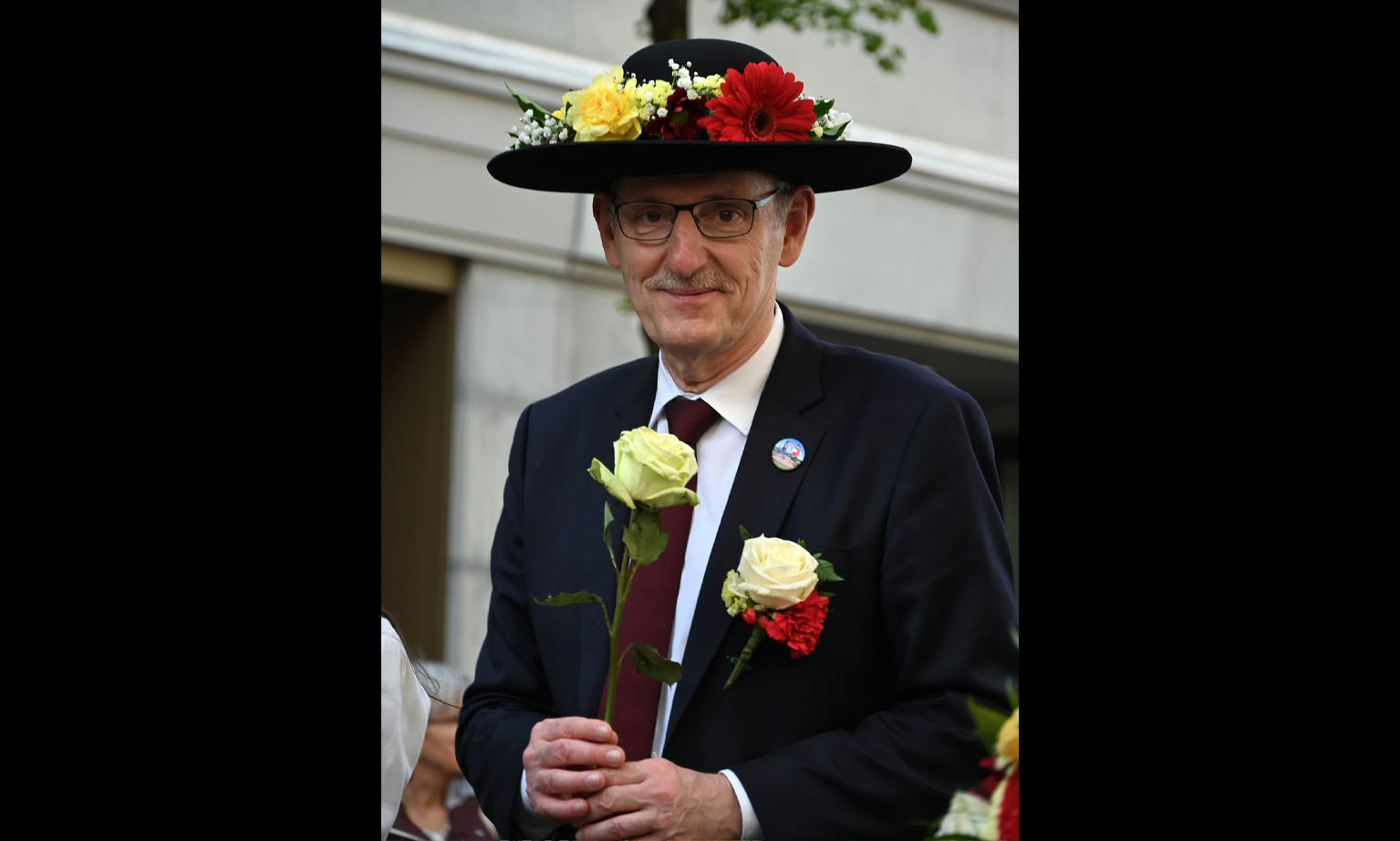Mario Fehr mit einem blumengeschmückten Hut, als Ehrengast der Zunft Wollishofen. 