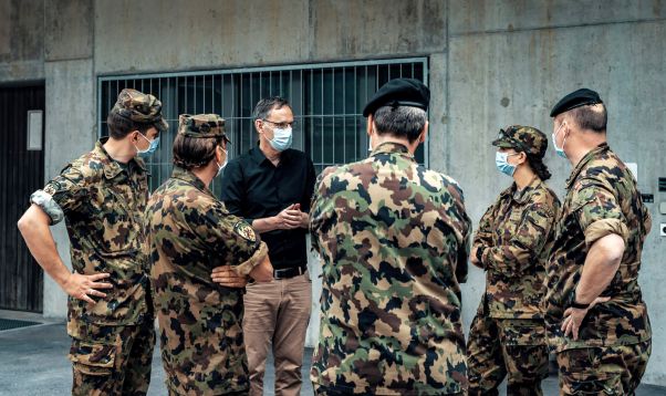 Lagebesprechung beim Militär: Mario Fehr trägt eine Schutzmaske und spricht mit mehreren Personen. 