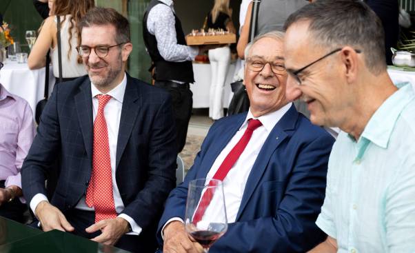Mario Fehr, der Basler Regierungsrat Conradin Cramer und Alt-Bundesrat Adolf Ogi befinden sich im Gespräch und lachen herzlich. 