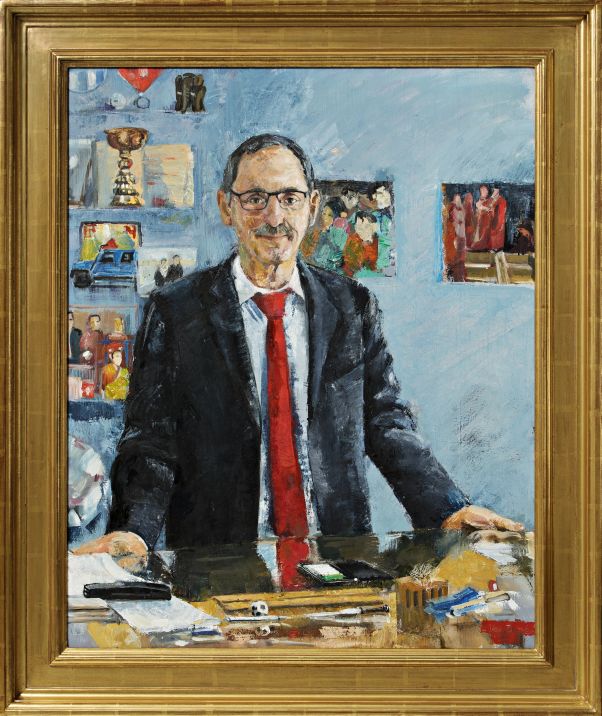Offizielles Porträt Regierungspräsident: Mario Fehr steht hinter seinem Schreibtisch, an der Wand hängen Pokal- und Fussballbilder. 