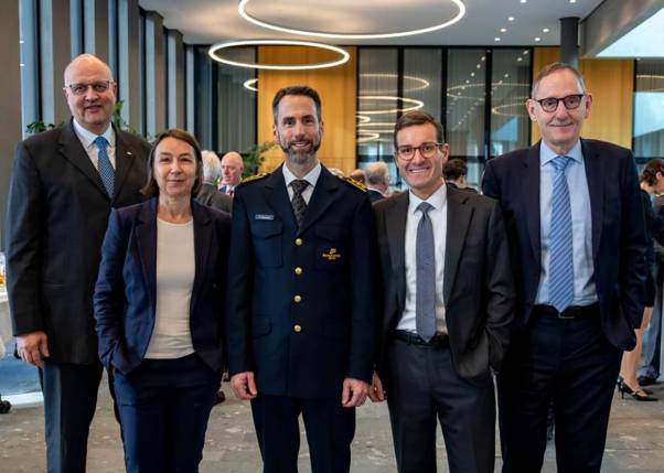 Markus Schaaf, Andrea Gisler, Marius Weyermann, Tobias Weidmann und Mario Fehr stehen nebeneinander und schauen freundlich in die Kamera. Im Hintergrund ist der helle, moderne Raum des Polizei- und Justizzentrums zu sehen. 