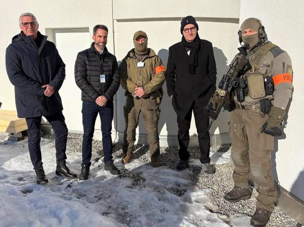 Mario Fehr steht neben Marius Weyermann und weiteren Polizeiangehörigen auf einem leicht schneebedeckten Kiesplatz in Davos. 