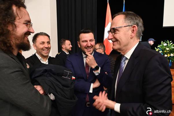 Mario Fehr steht im Anzug an der Feier des Kosova neben mehreren Personen, alle lachen. 