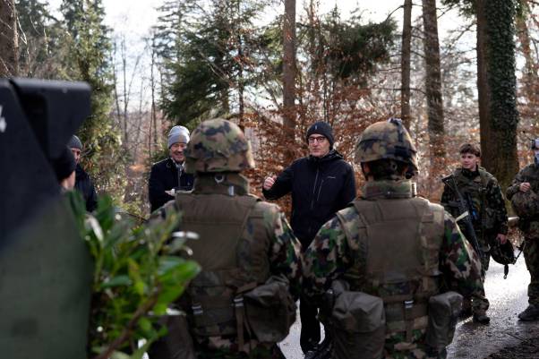 Mario Fehr steht neben Amtschef Thomas Bär und Angehörigen des Bataillons im Wald und diskutiert. 